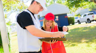 Fire Combo Awareness Day - the photo shows a chief fire warden in a white vest and white cap with a fire warden in a red vest and red cap looking at documents at an assembly point.