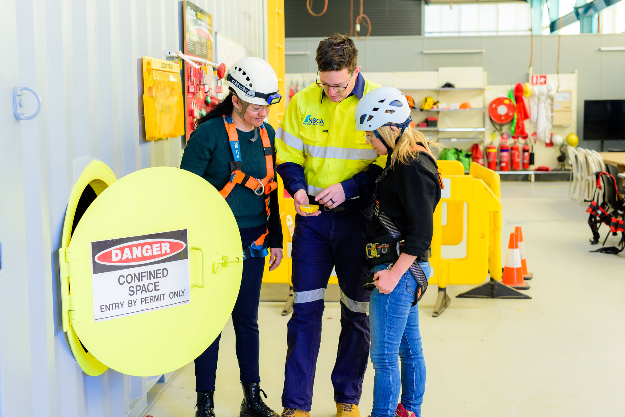 Confined space entry training showing a trainer and two learners with a gas test monitor