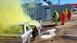 HAZMAT Response course showing a hazardous yellow smoke and emergency response crew in protective equipment