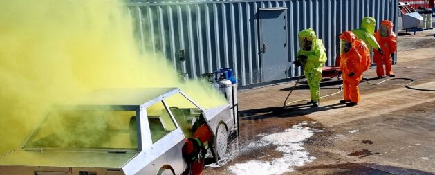 HAZMAT Response course showing a hazardous yellow smoke and emergency response crew in protective equipment