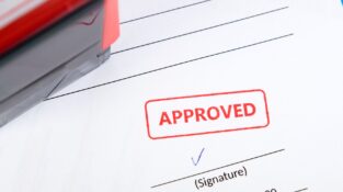 Issue Work Permits - "Approved" stamp on a document with a signature line.