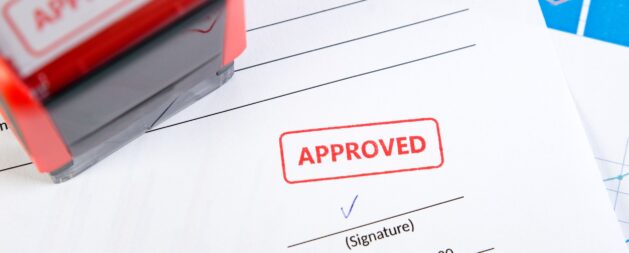 Issue Work Permits - "Approved" stamp on a document with a signature line.